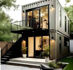 a house made out of shipping containers with stairs leading up to the second floor and windows