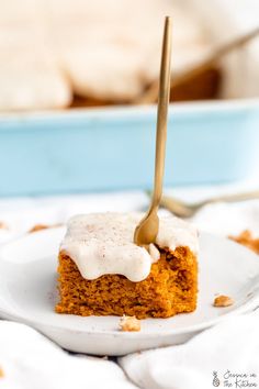 a piece of cake on a white plate with a fork sticking out of the top