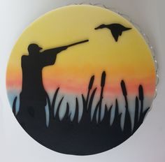 a cake decorated with the silhouette of a man shooting a bird