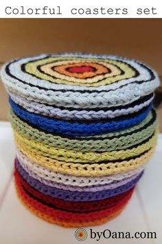 a stack of multicolored crocheted coasters sitting on top of each other