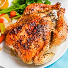 a close up of a chicken on a plate with vegetables