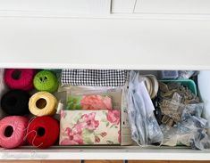 an open drawer filled with yarn and other items