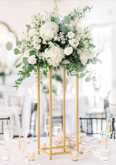 an elegant centerpiece with white flowers and greenery