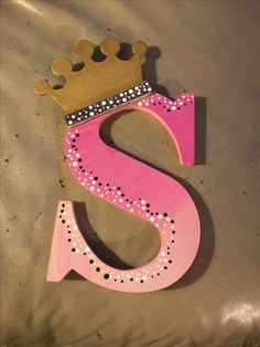 the letter s is made out of wood and has a crown on top of it