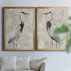 two paintings of birds are hanging on the wall