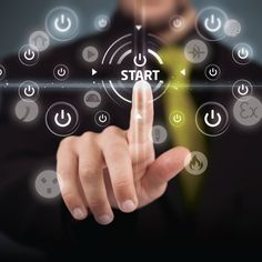 a man in a business suit touching the start button on a touch screen with his finger