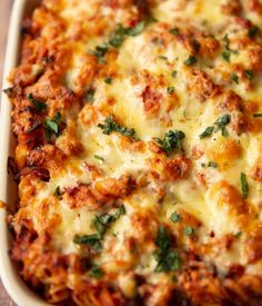 a casserole dish with cheese and spinach on top, ready to be eaten