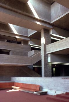 an empty room with stairs and benches in the center, surrounded by concrete blocks on either side