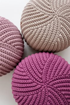 three crocheted balls sitting next to each other on top of a white surface