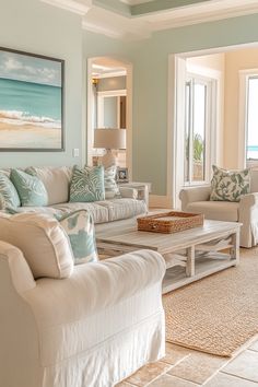 a living room filled with white furniture and lots of pillows on top of the couches