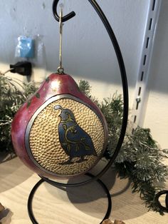 a decorative bird ornament hanging from a wire on top of a wooden table