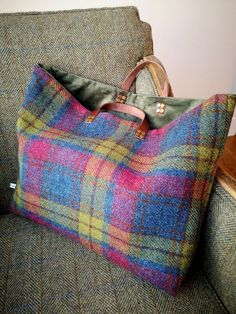 a plaid bag sitting on top of a couch