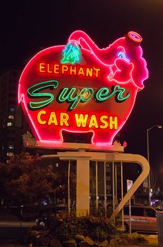 an elephant super car wash sign lit up at night