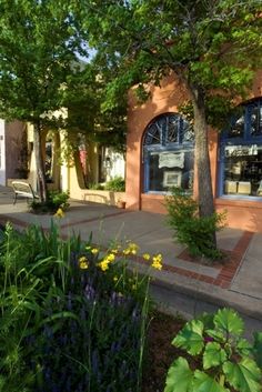 an outside view of a building with flowers and trees