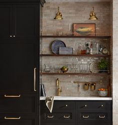 the kitchen is decorated in black and gold with brass accents, such as shelving above the sink