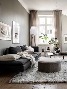 a living room filled with lots of furniture and decor on top of a hard wood floor