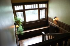 the stairs lead up to an upstairs room with wood paneling and wooden railings