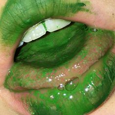 a woman's lips with green and white makeup