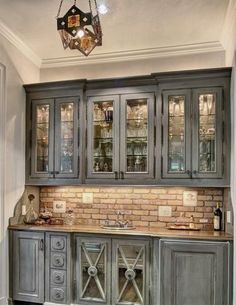 an old fashioned kitchen with grey cabinets and wood flooring is featured in this image