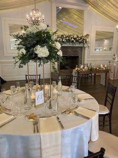 the table is set with white flowers and candles