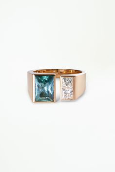 a gold ring with an aqua and white topazte stone set in the center