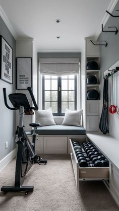 a room with a bike, exercise equipment and a couch in it's corner