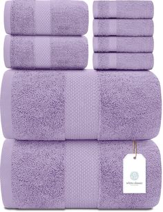 six purple towels stacked on top of each other with a tag hanging from the front