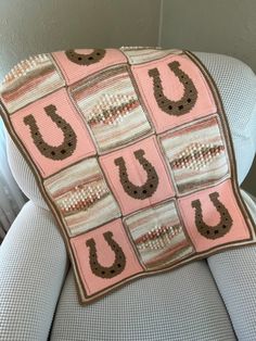 a pink and brown blanket sitting on top of a chair