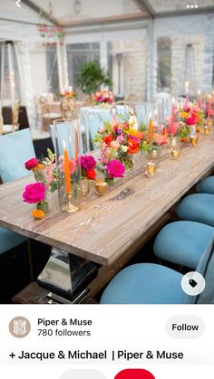 a long wooden table topped with lots of vases filled with colorful flowers and candles