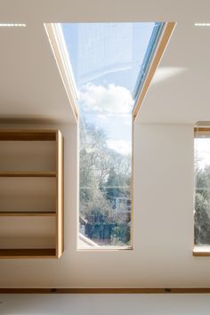 an open window in the corner of a room with bookshelves on either side