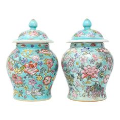 two blue vases with flowers painted on them are next to each other, one has a lid