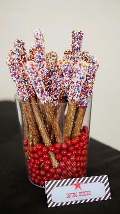 a glass filled with candy canes and sprinkles on top of a table