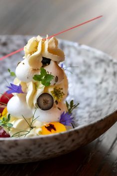 a white bowl filled with food on top of a wooden table