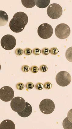 the word happy new year spelled out in small letters on top of confetti