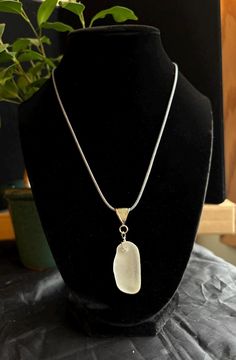 Discover the timeless allure of our thick curved frosted white pendant necklace, a unique piece of wearable art that embodies the beauty and tranquility of Lake Michigan. This exquisite pendant features genuine sea glass, meticulously handpicked from the shores of Lake Michigan and expertly handcrafted into a one-of-a-kind accessory. Specifications: -Pendant length:  around 1.5 inches -Amount of sea glass: 1 piece -Chain Length: 20" chord adjustable -Clasp:lobster claw  adjustable -Materials: Genuine Lake Michigan sourced Sea Glass,stainless steel nickel-free metal chain, wire, cord Features: -Authentic Lake Michigan Sea Glass: Carefully handpicked from the pristine shores of Lake Michigan, ensuring a one-of-a-kind piece that is never reshaped. When picking pairs we look for similarities b Silver Adjustable Necklace With Oval Pendant, Adjustable Silver Necklace With Oval Pendant, Unique White Adjustable Necklace, White Oval Pendant Jewelry With Adjustable Chain, Unique White Round Pendant Necklace, White Rectangular Pendant Necklace For Gift, White Necklace With Large Pendant, Unique White Necklace With Large Pendant, White Necklace With Rectangular Pendant For Gift