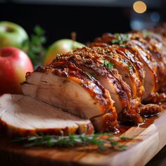 sliced pork on a cutting board with apples in the background