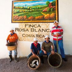 three men standing next to each other in front of a sign that says cafe finca rosa blanc costa rica