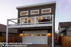 a two story house with a car attached to the top floor and balcony above it