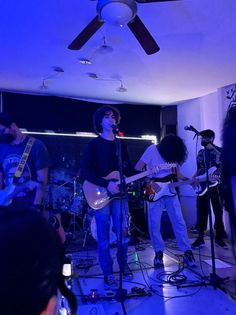 a group of people that are standing in front of microphones and guitar's