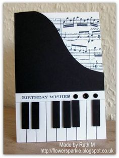 a birthday card with piano keys and music notes on the front, in black and white