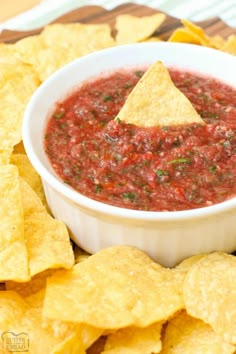 a white bowl filled with salsa surrounded by tortilla chips