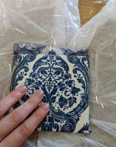 a hand is holding onto a blue and white napkin