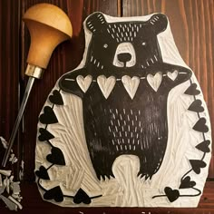 a bear with hearts on it is next to a carving knife and some wood shavings