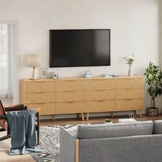 a living room with couches, chairs and a flat screen tv on the wall