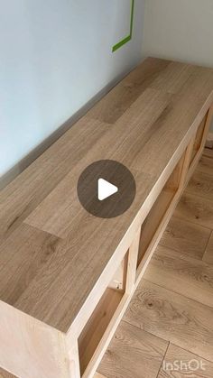 a wooden bench sitting on top of a hard wood floor next to a white wall