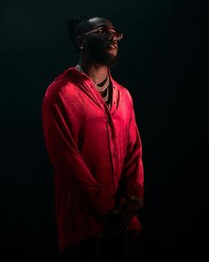 a man in a red shirt and black pants standing with his hands on his hips