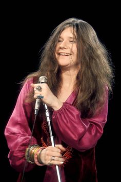 a woman with long hair holding a microphone