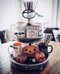 three tiered tray with halloween themed coffee cups and mugs sitting on top of each other