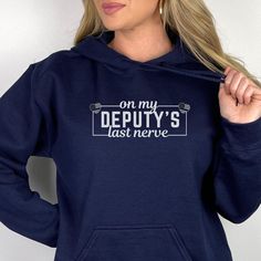 Deputy Wife Crewneck Sweatshirt, Hoodie, Long Sleeve Tee or T-shirt is the perfect gift for any deputy wife, fiance or girlfriend for her birthday or Christmas! T-shirt: This is made with the Bella & Canvas 3001 classic unisex jersey short sleeve tee.  It fits like a well-loved favorite, soft cotton and quality print make users fall in love with it over and over again. These t-shirts have-ribbed knit collars to bolster shaping. The shoulders have taping for better fit over time. Dual side seams Deputy Shirt, Cop Wife, Police Wife Shirt, Deputy Wife, Police Officer Wife, Leo Wife, Police Wife, Sheriff Deputy, Nerve