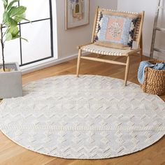 a white rug in the middle of a room with a chair and potted plant